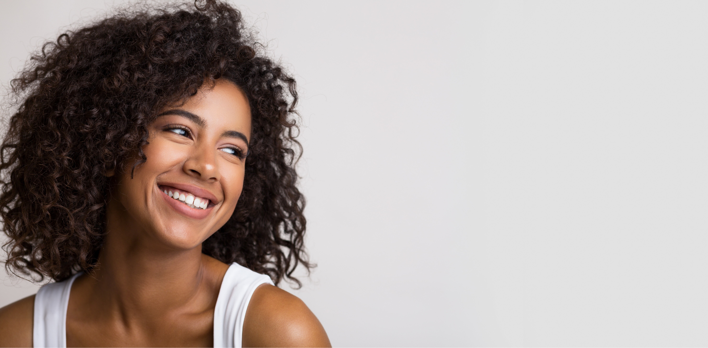 Smiling woman wearing a white tank top