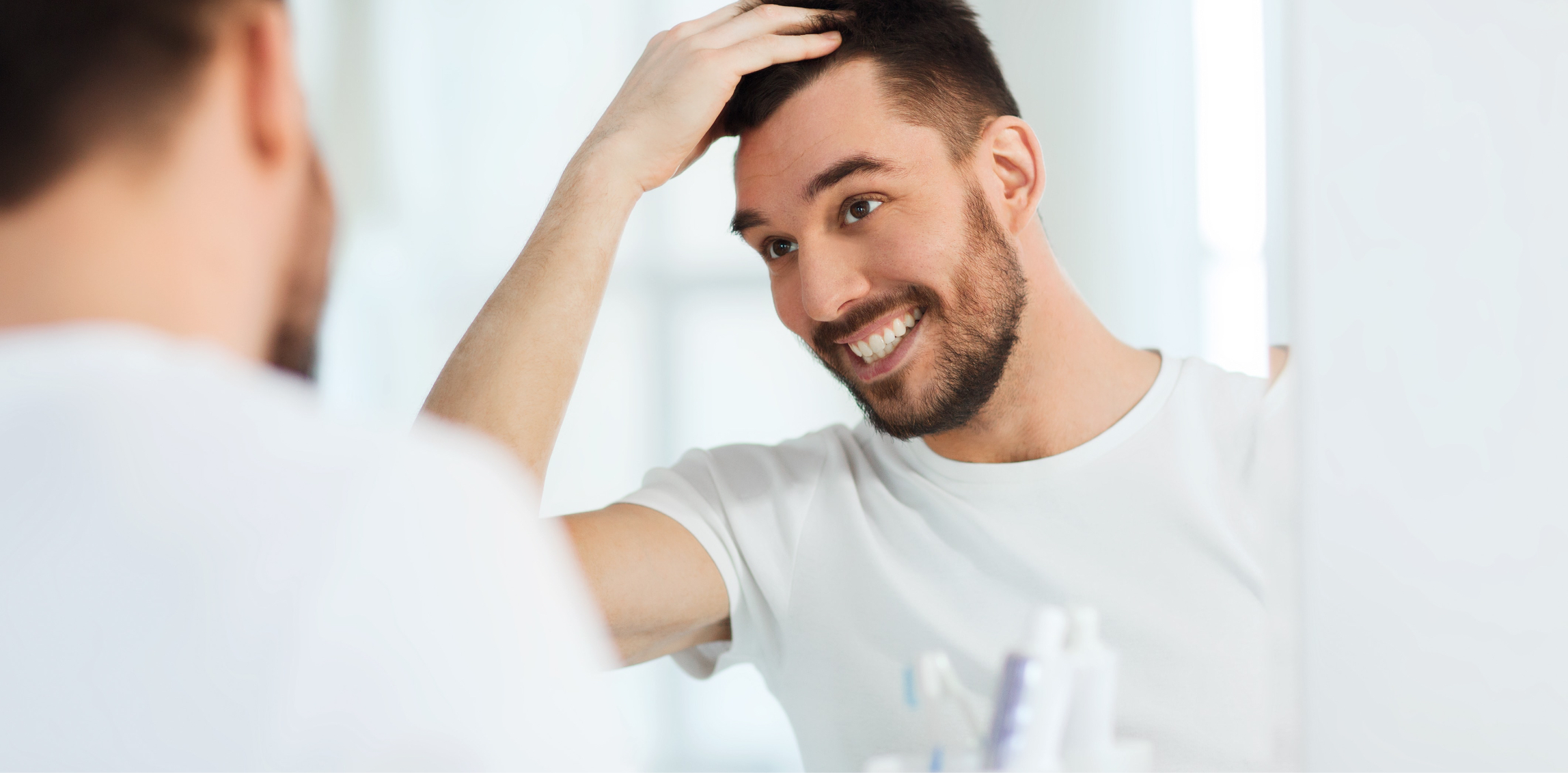 Man looking at his hair in the mirror