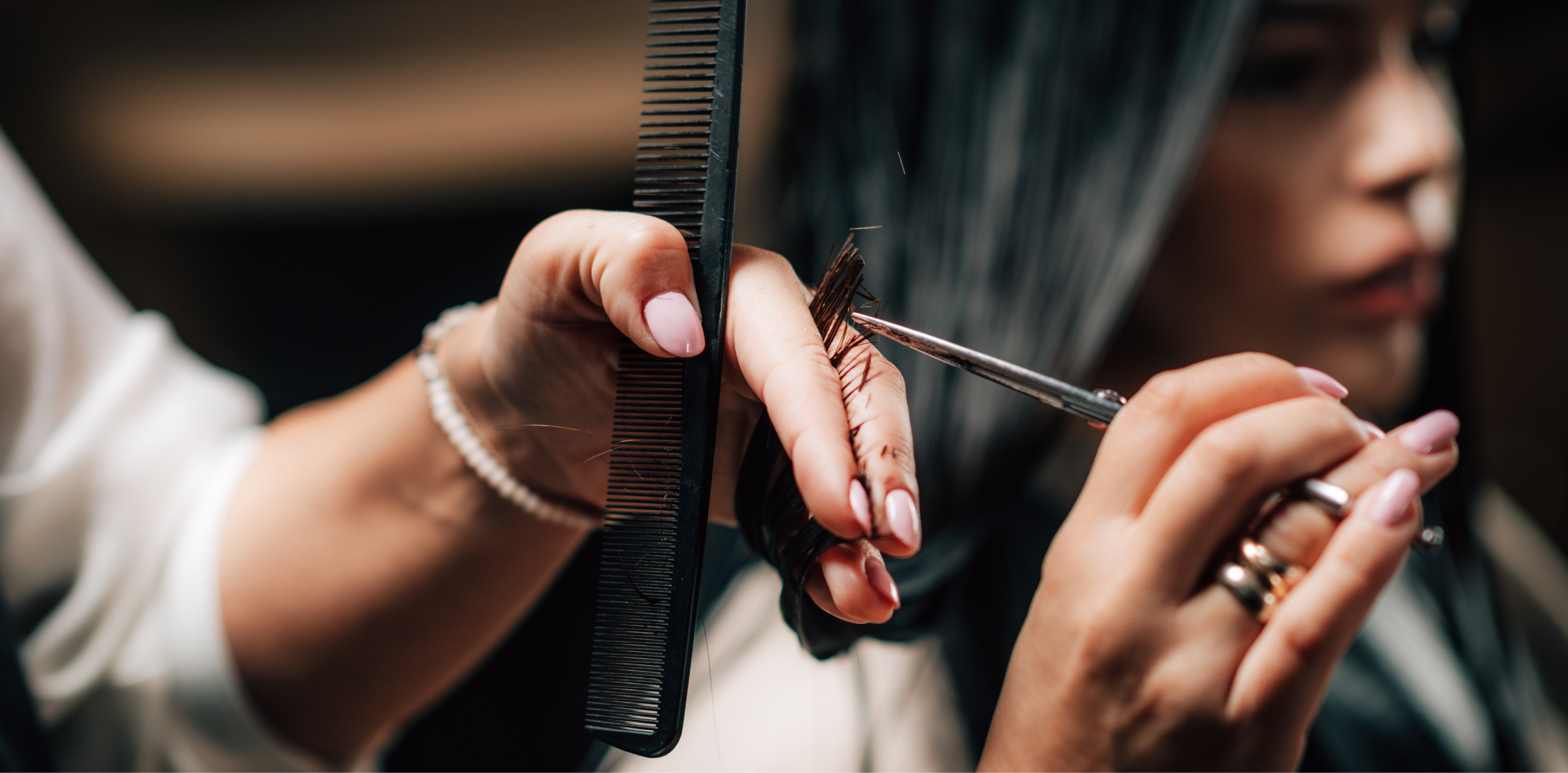 Close-up on hands cutting a person's hair