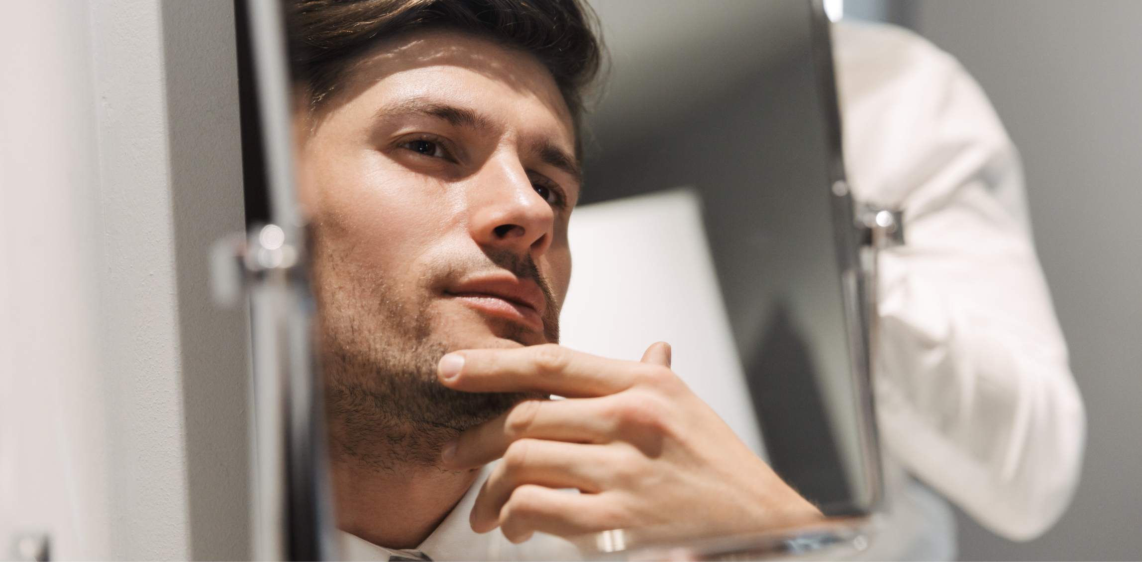 Man looking at his face in the mirror